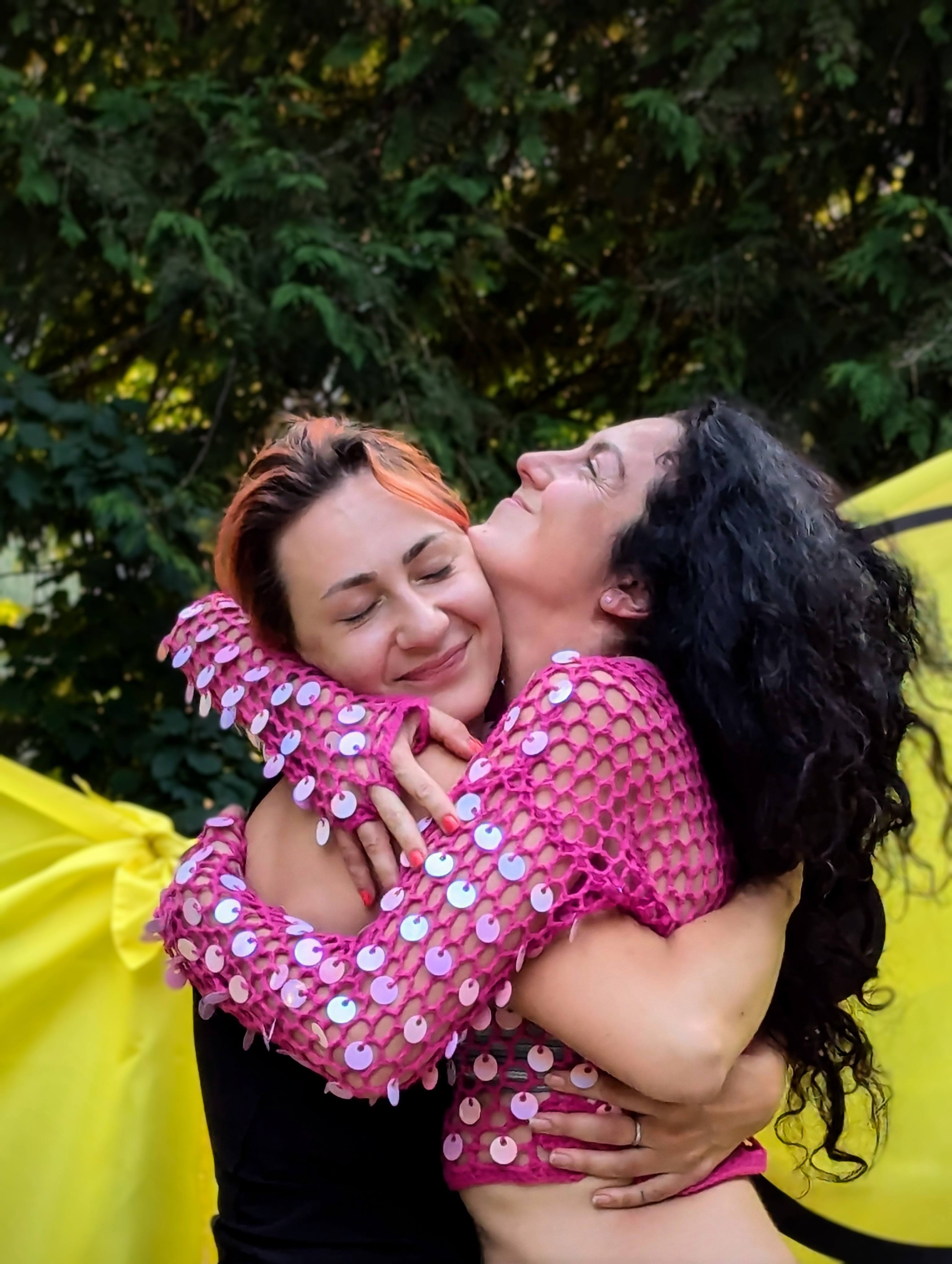 Two attendees in a warm embrace at Bass n Nova
